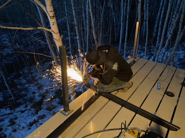 A new steel-and-cable deck railing being installed during the renovation