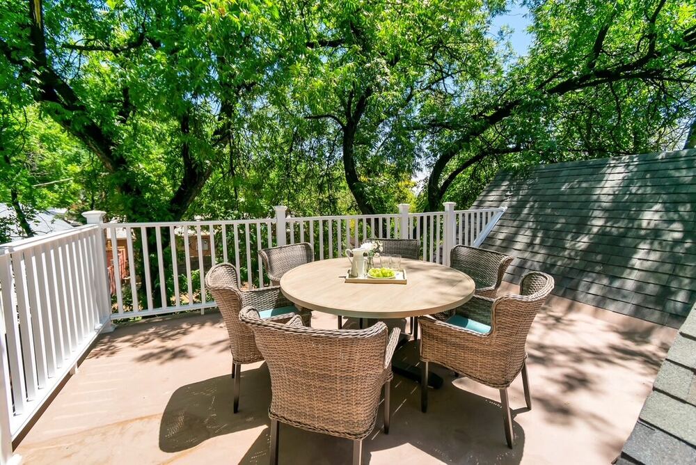 The same rooftop space transformed into a furnished deck with white railing