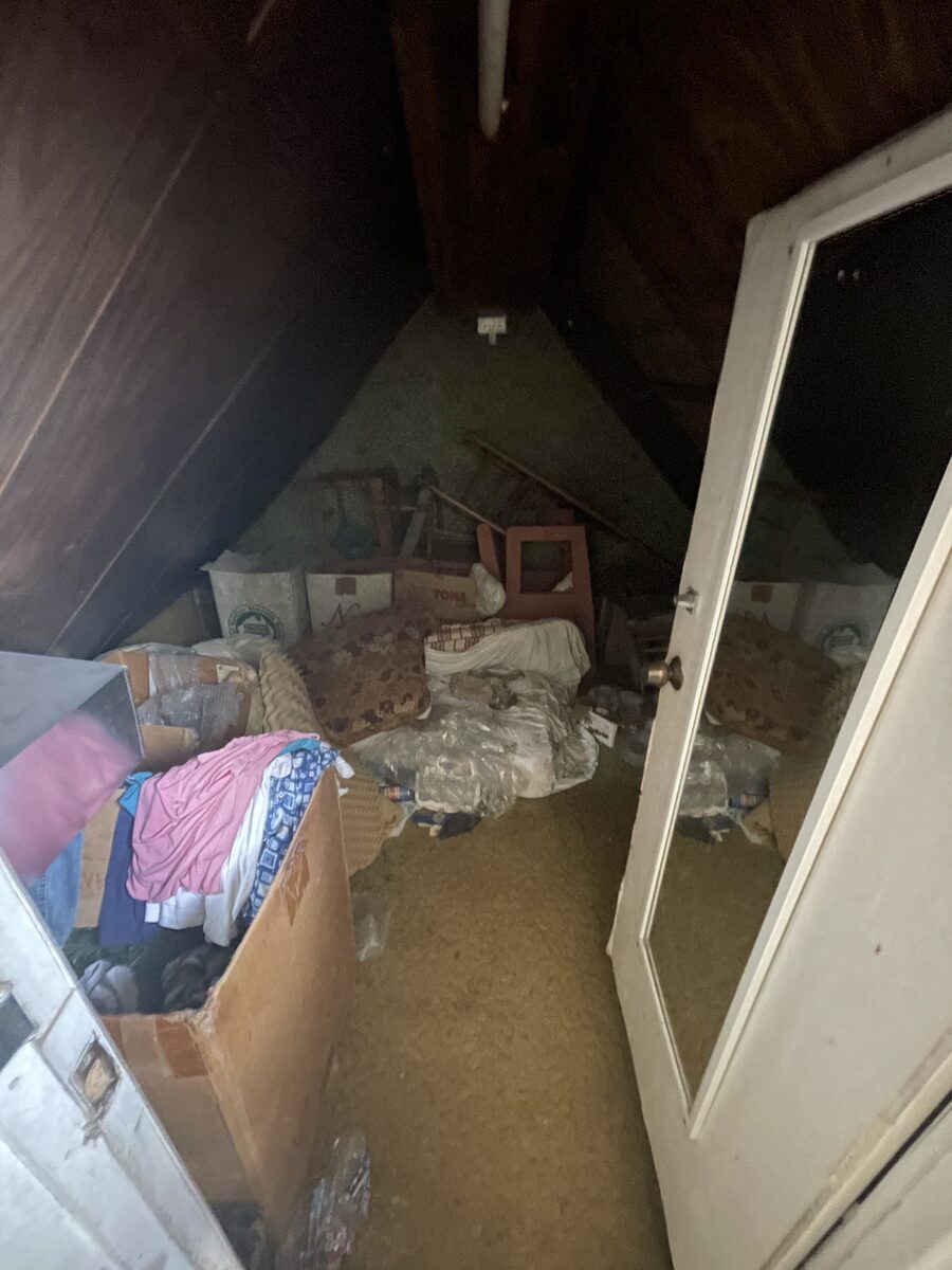 A cluttered, unfinished attic storage space full of old belongings