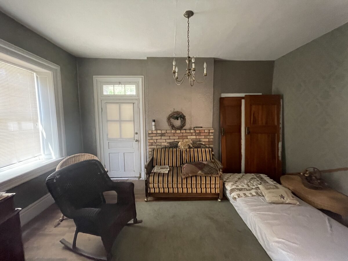 A cluttered spare room before renovation, later restored as the library