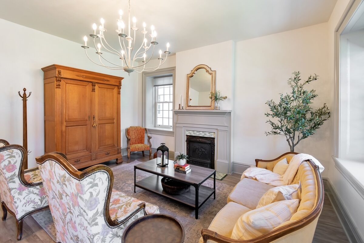 The renovated living room around the original fireplace mantle, with fresh paint and furnishings