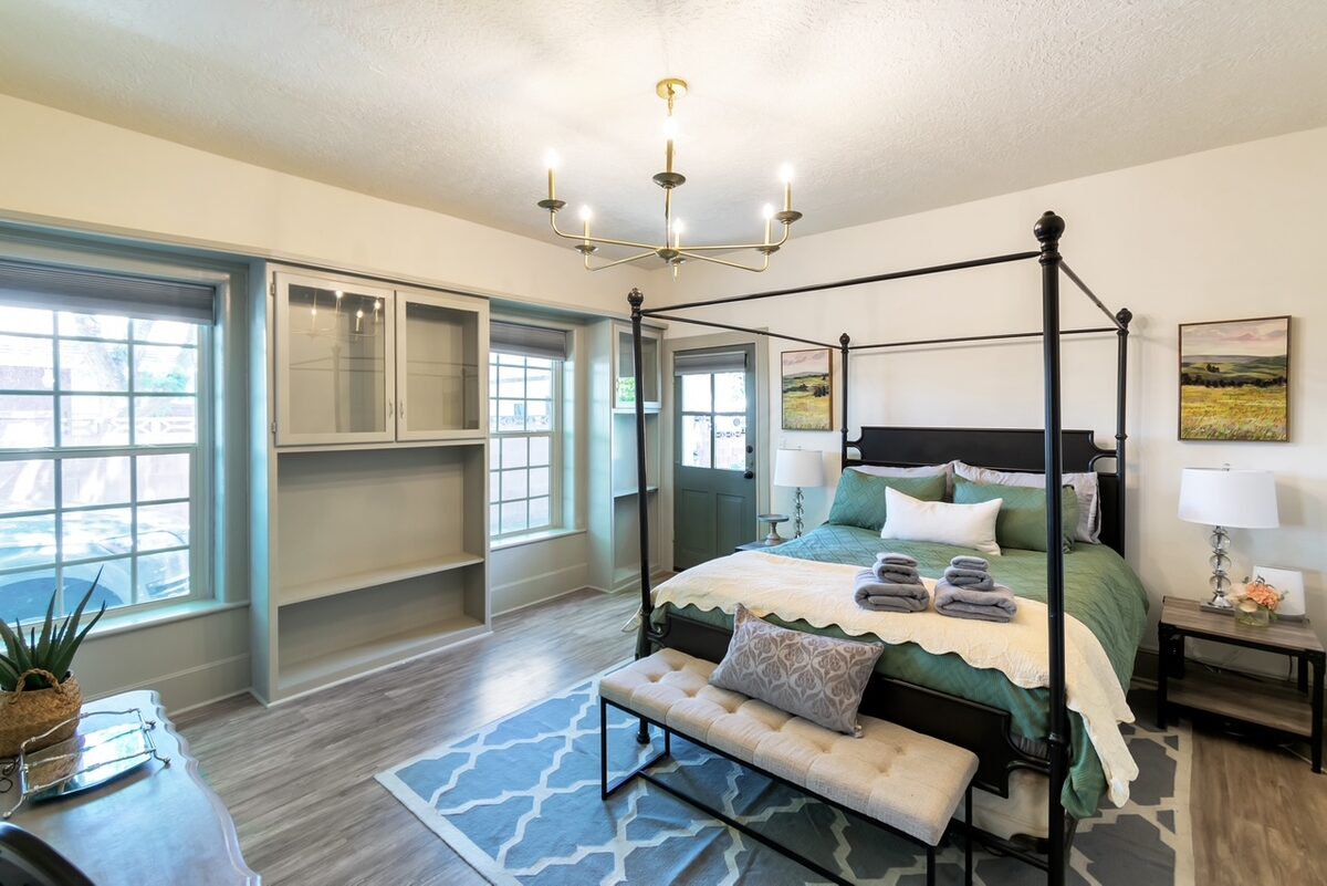 The restored primary bedroom with a canopy bed frame